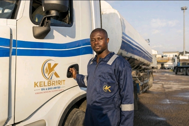 A KELBRIRIT driver standing beside a company tanker.